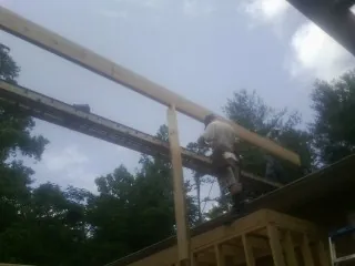 Carpenter setting a ridge beam over a new addition frame — Ice Dam Removal by Roofing Brothers in Criders