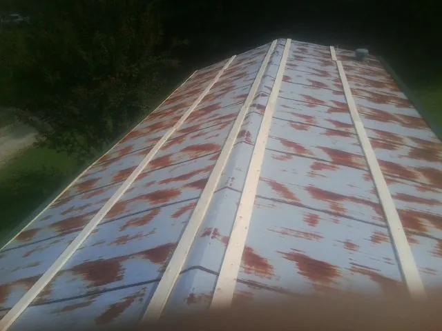 Rusted metal roof panels with new wood purlins before replacement — Storm Damage Roof Repair in Criders by Roofing Brothers