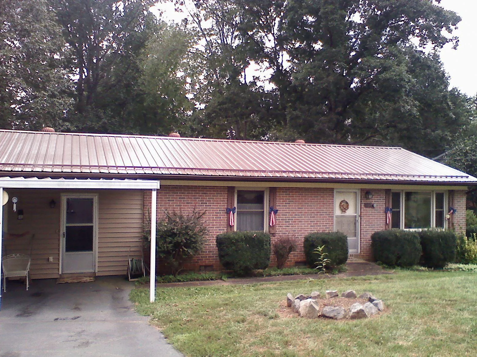 Bronze metal roof and carport on a brick ranch home — Roof Repair work by our crew in Criders